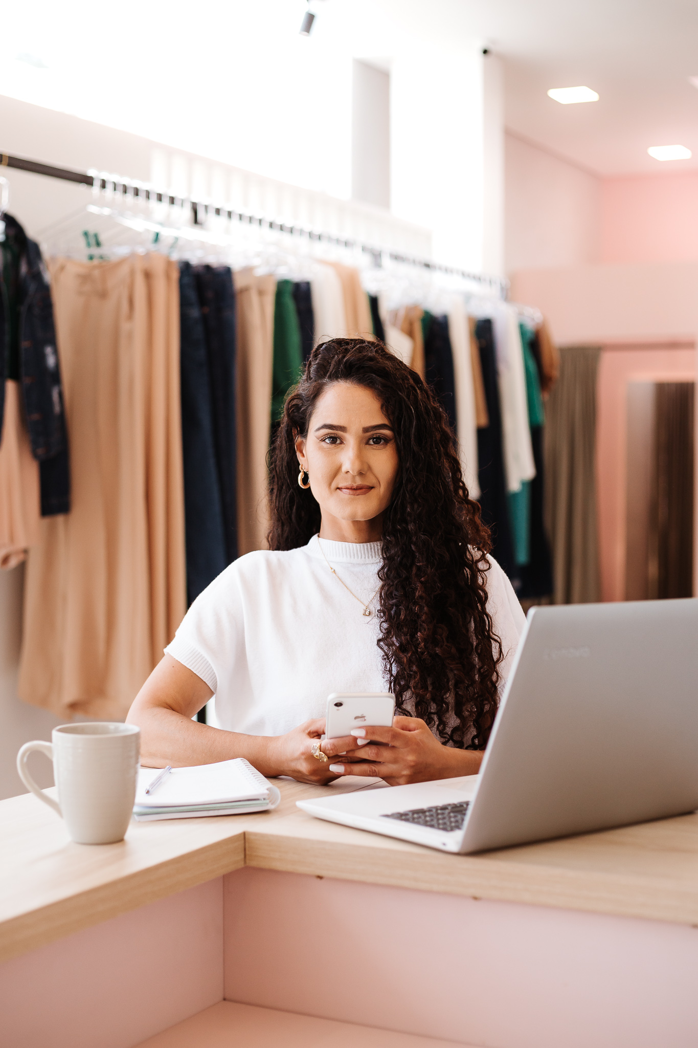 Luana Pereira no computador em uma loja de moda